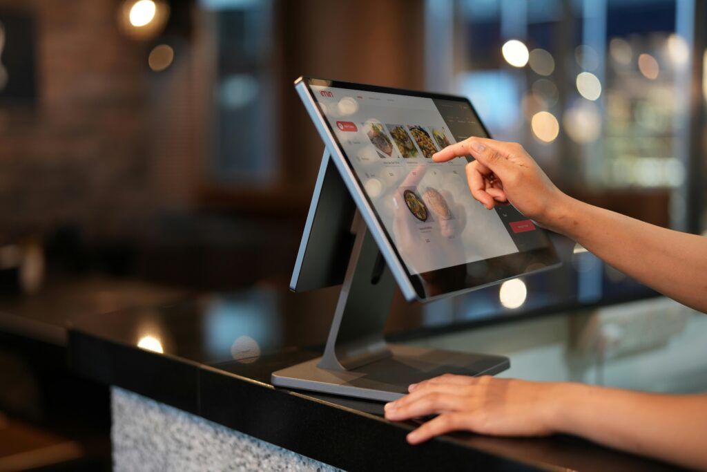 pexels photo 12935074 12935074 Close-up of a hand interacting with a touchscreen POS system in a restaurant setting.