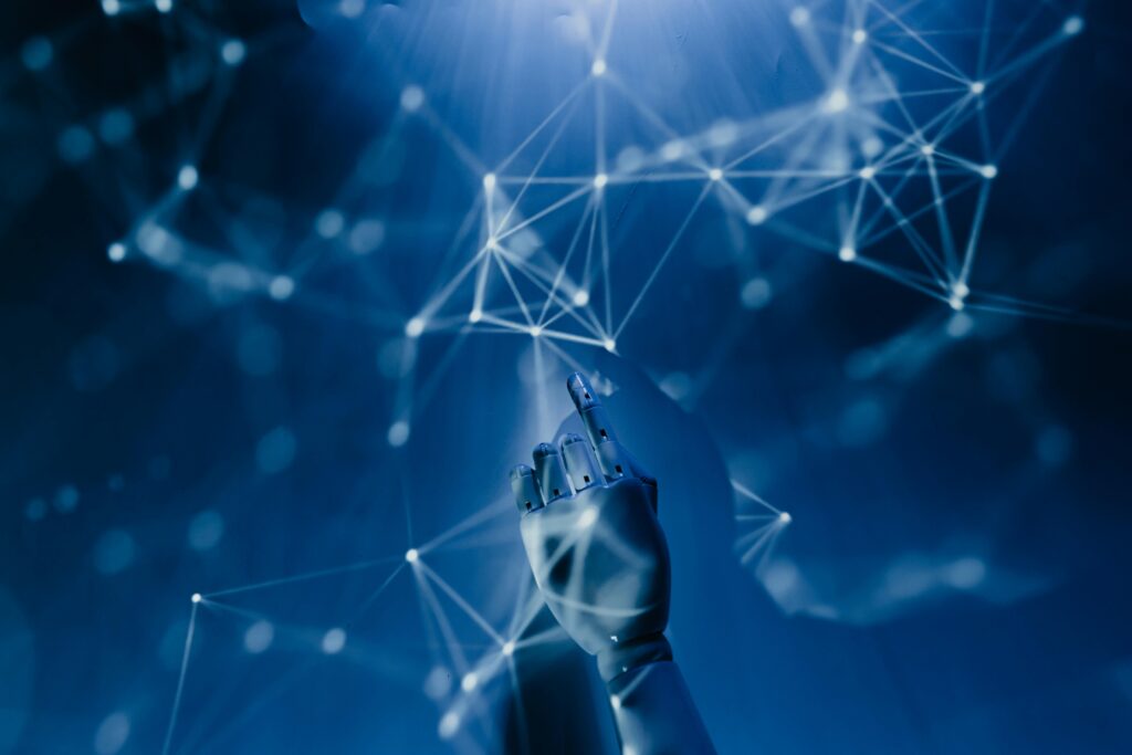pexels photo 8386440 8386440 A robotic hand reaching into a digital network on a blue background, symbolizing AI technology.